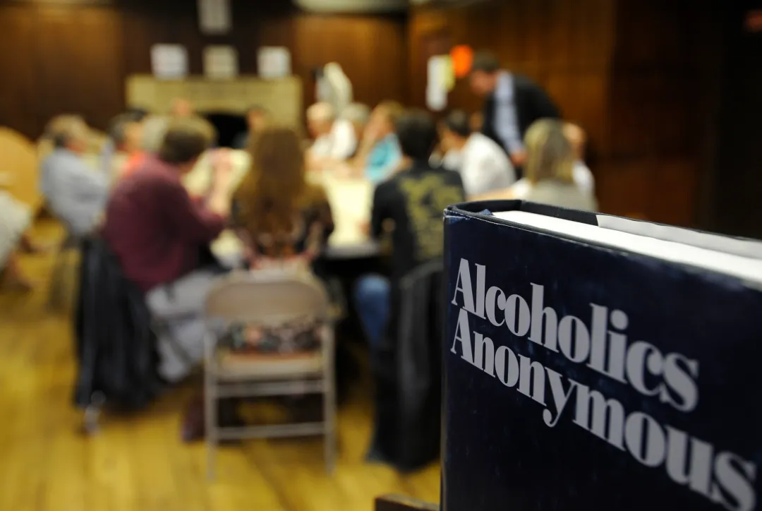 A copy of the Alcoholics Anonymous Big Book in a meeting room.
